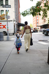 Woman walking with a child on a city street, Exxpress truck in the background